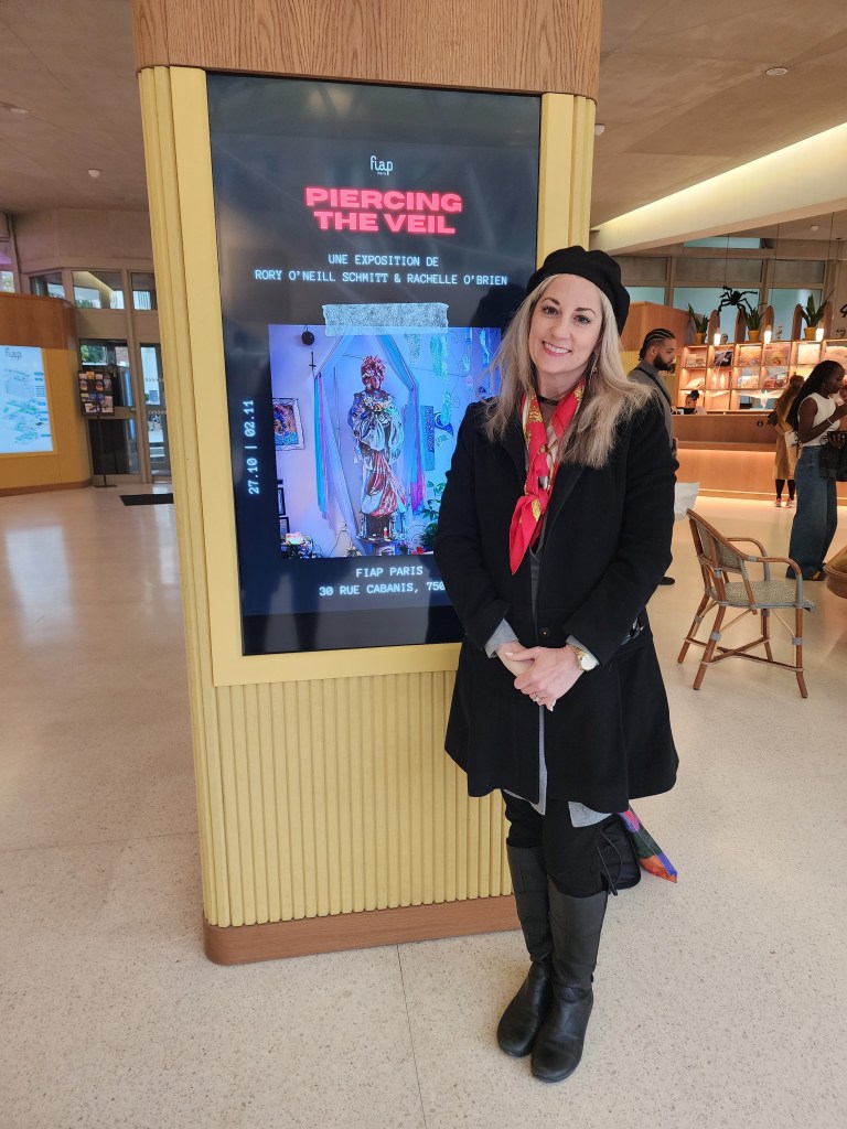 Rory standing in front of the exhibition poster 'Beyond the Veil,' at FIAP in Paris. The exhibition is of photographs that Rory and Rachelle, her sister took of New Orleans and the buildings reputed to have ghosts. These photographs appear in 'The Haunted Guide to New Orleans' (Carole Di Tosti)