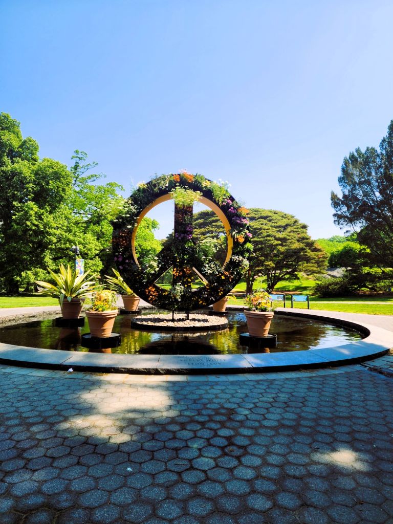 The peace sign bathed in flowers, reflecting pool installation at the Leon Levy Center, NYBG. (Carole Di Tosti)